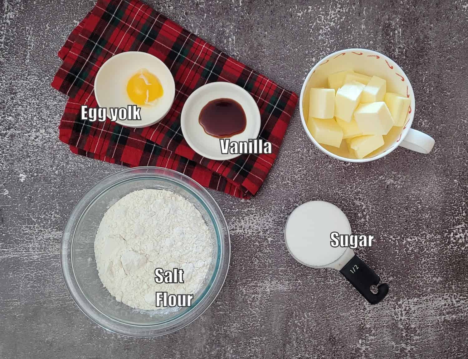 ingredients needed to make cookie part of Christmas shortbread including flour, salt, sugar, butter, vanilla and an egg yolk