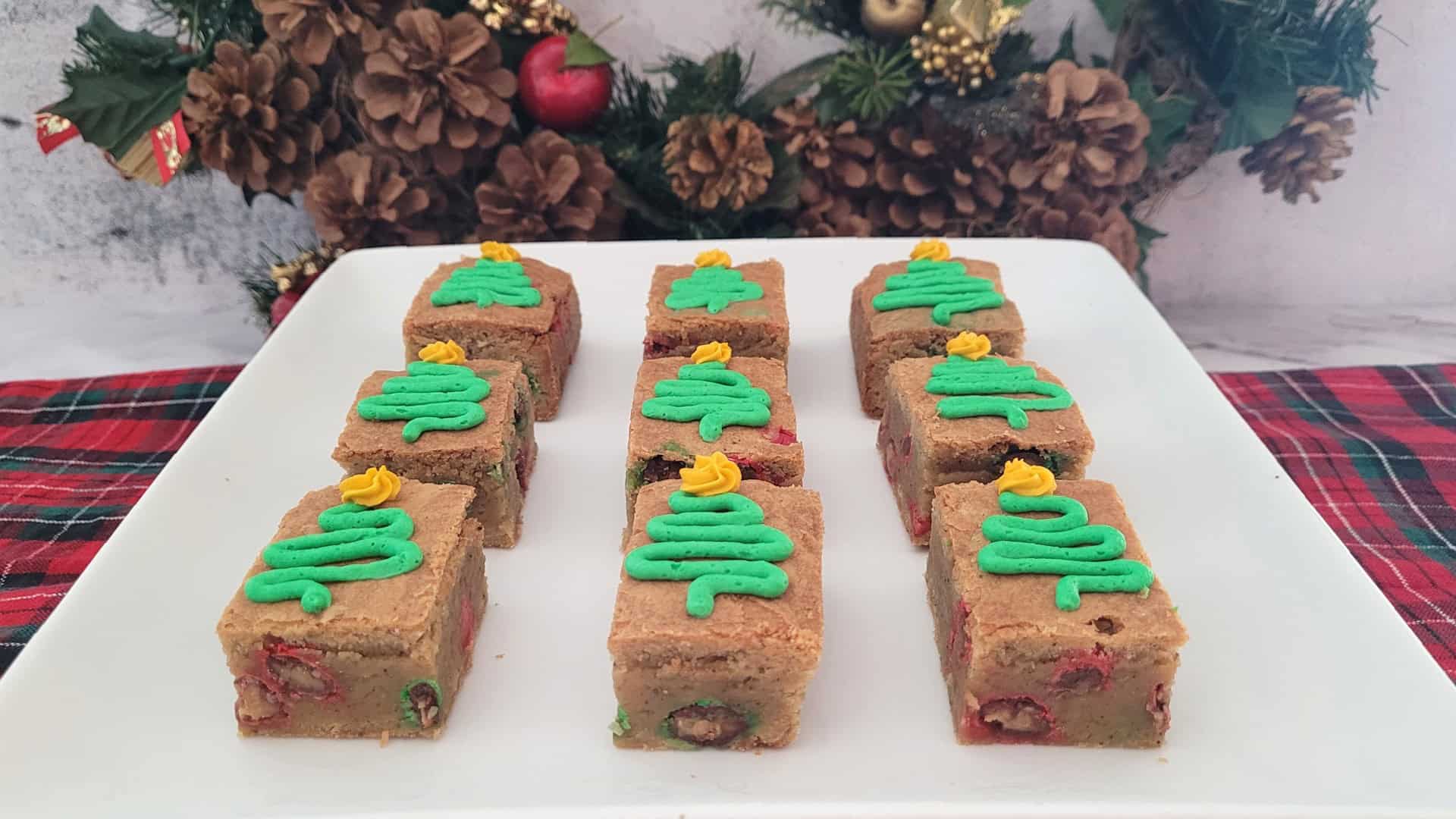 pieces of Christmas brown butter blondies decorated with buttercream Christmas trees