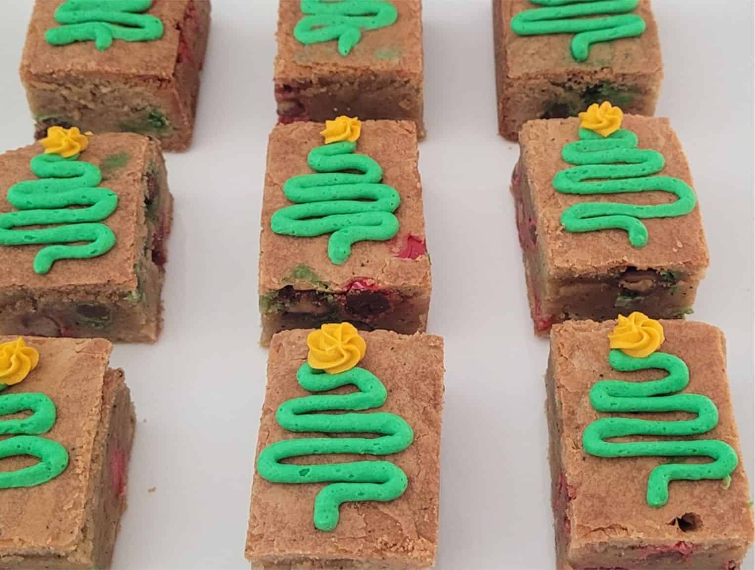 close up of blondies with Christmas trees and stars piped on with buttercream