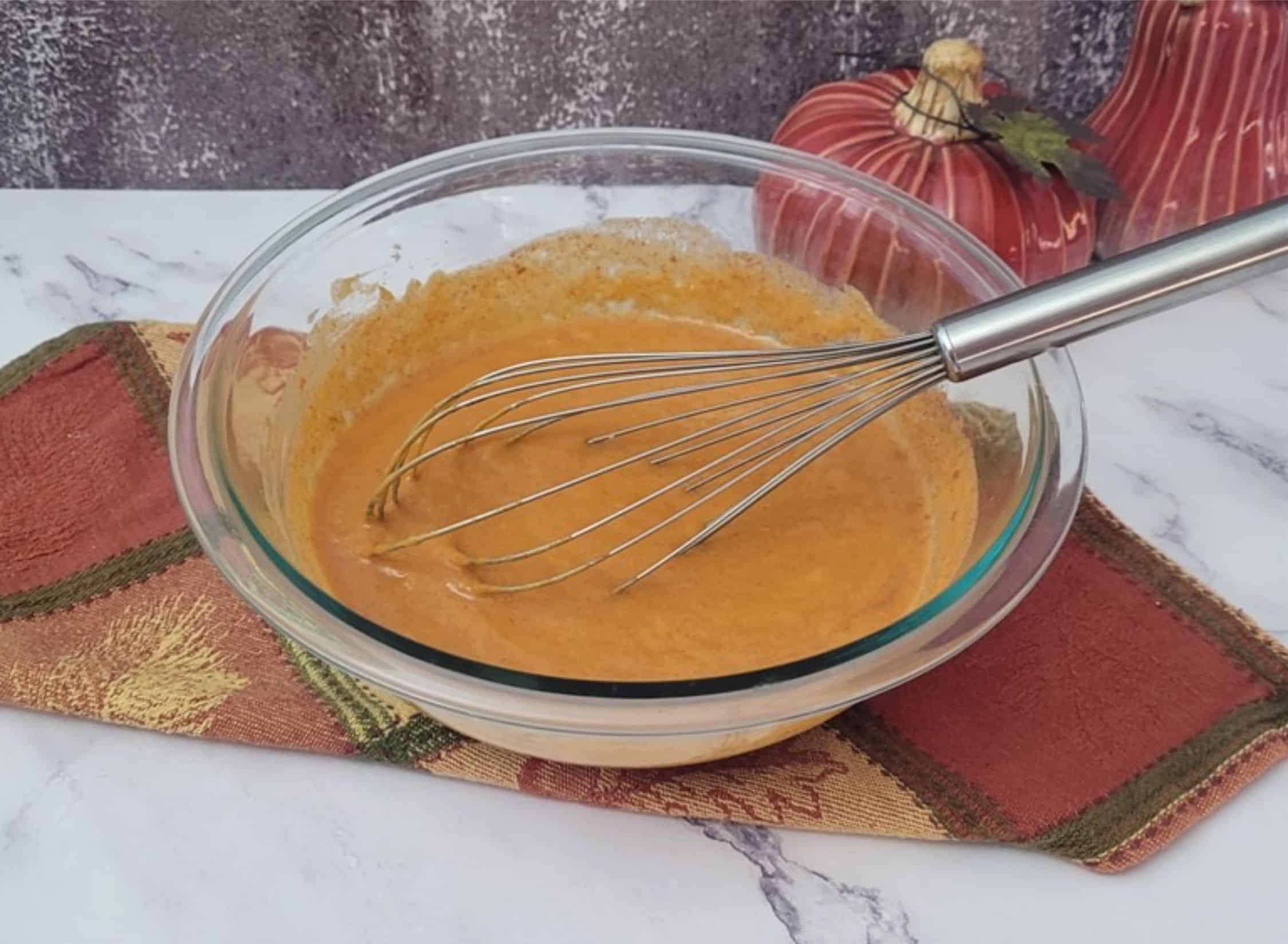 a bowl with pumpkin mousse ingredients combined by whisking together