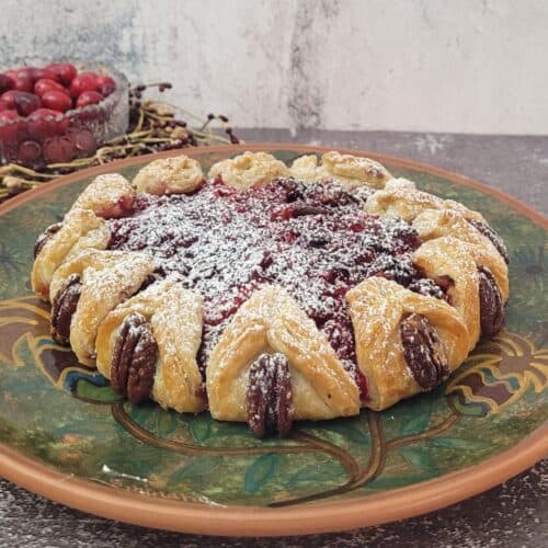 finished cranberry galette on a serving dish and dusted with powdered sugar