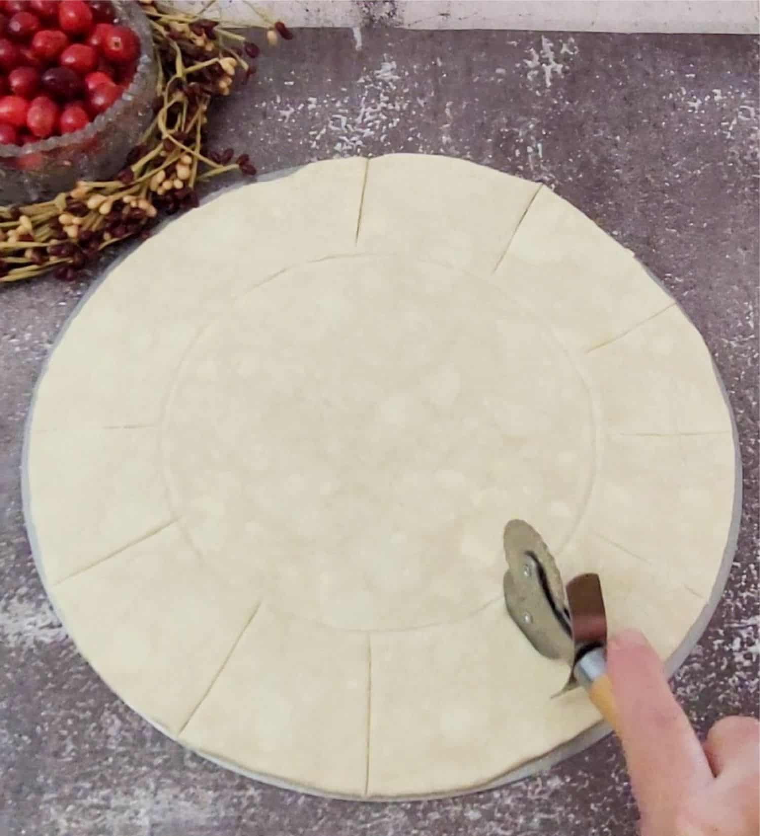 using a pizza cutter to cut slits in puff pastry