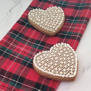 two decorated heart cookies made using gingerbread dough recipe