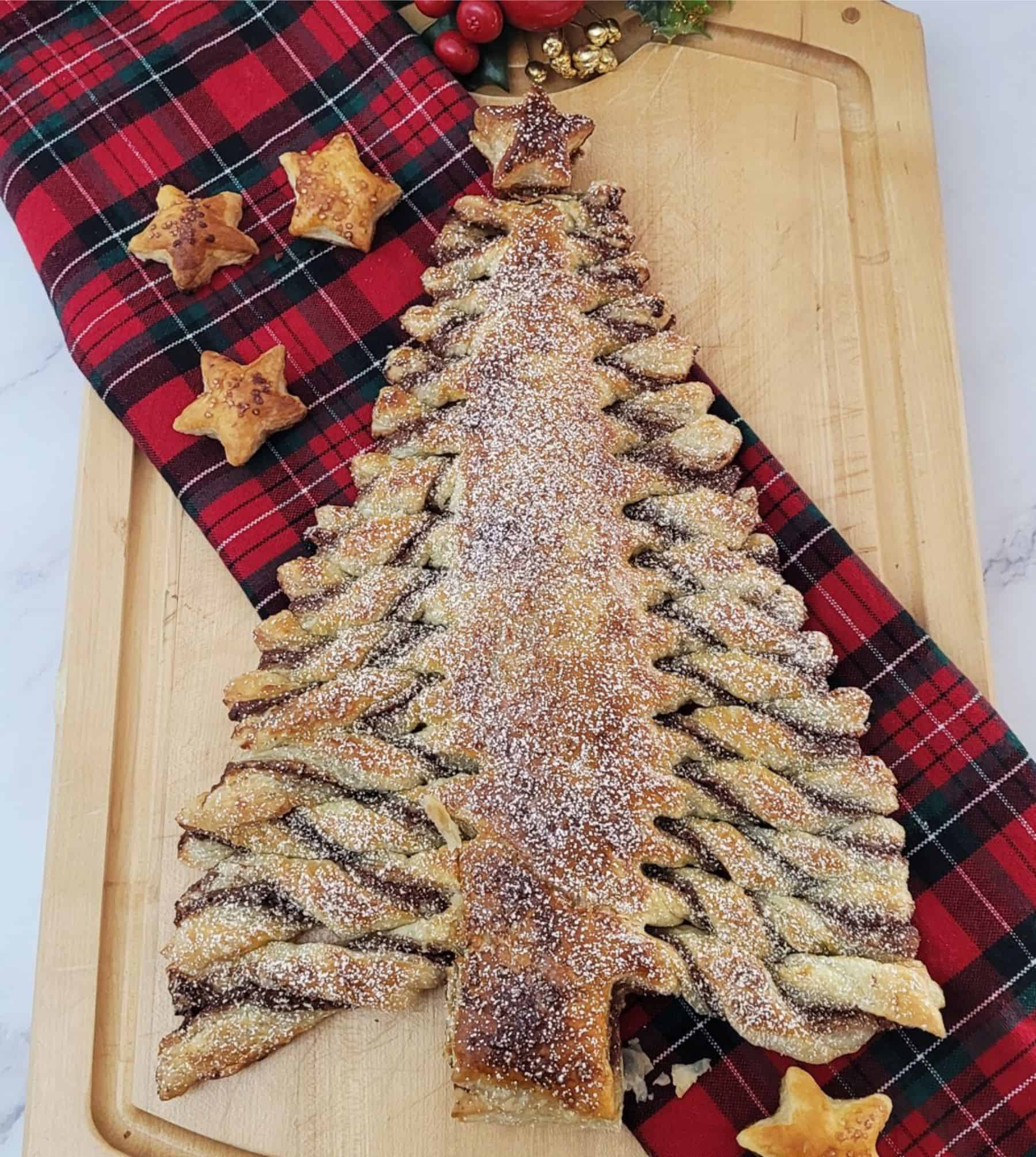 puff pastry Christmas tree dessert on a serving platter and sprinkled with powdered sugar