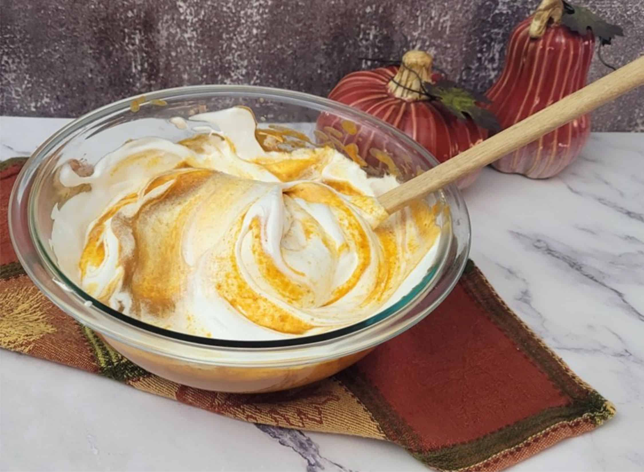 folding whipped egg whites into pumpkin mixture to finish mousse