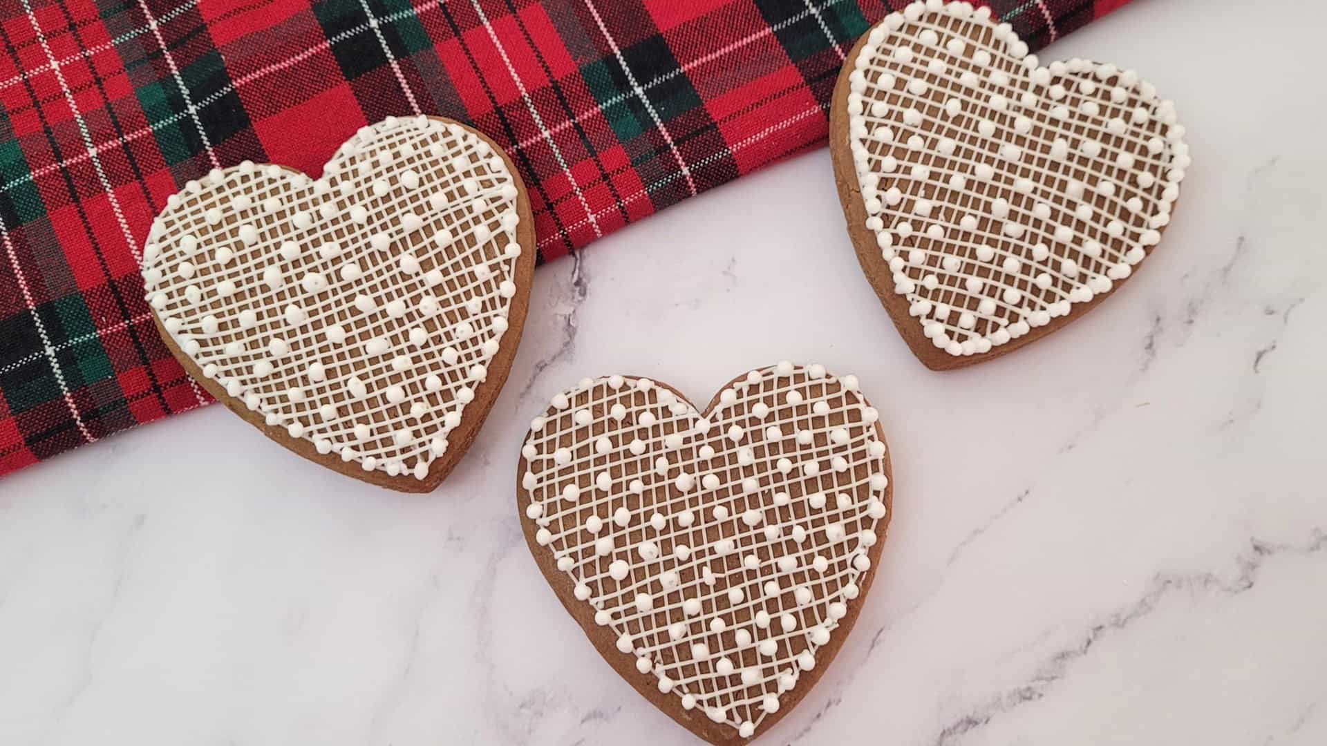 three decorated gingerbread heart cookies