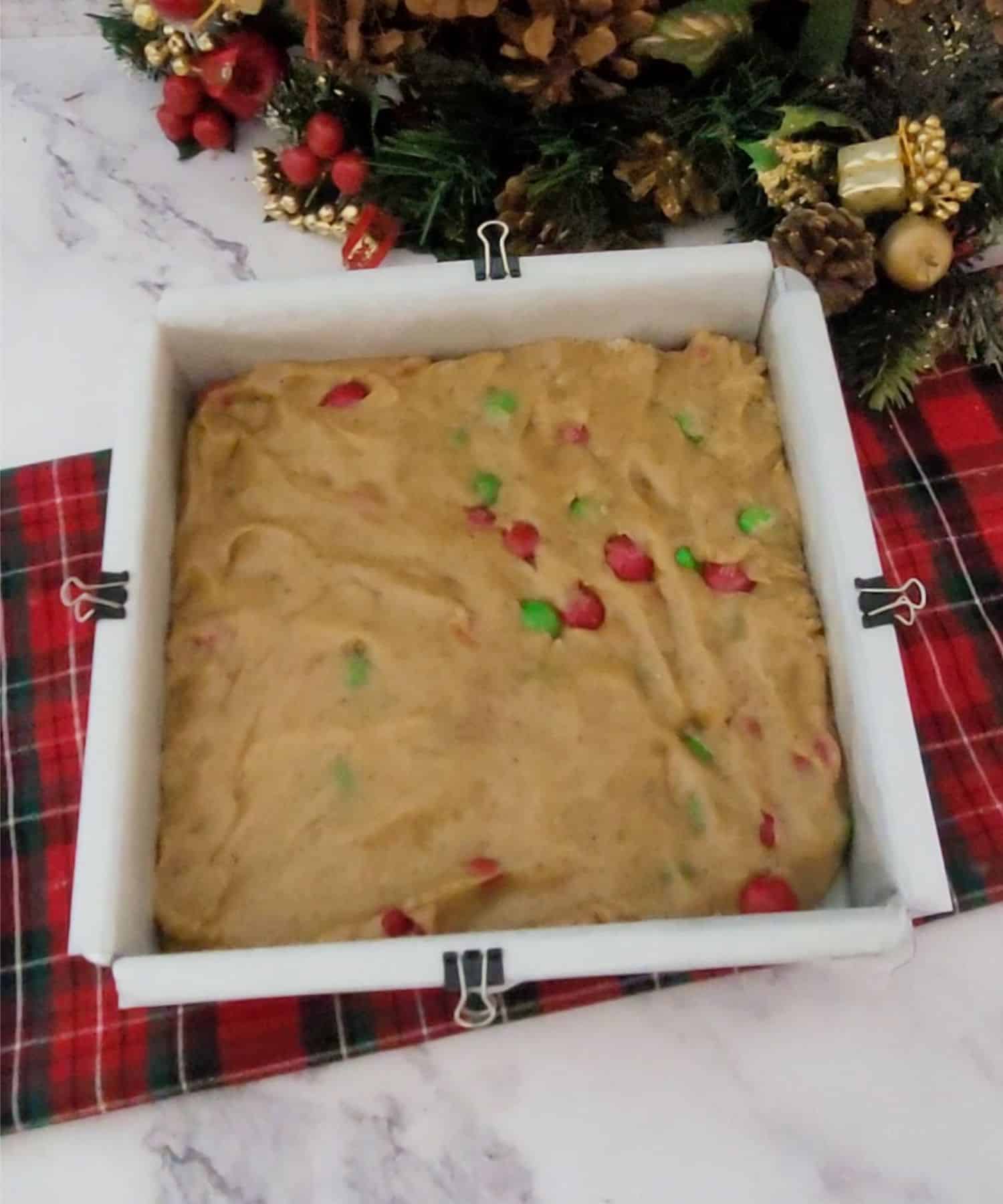 blondie dough pressed into a square baking pan