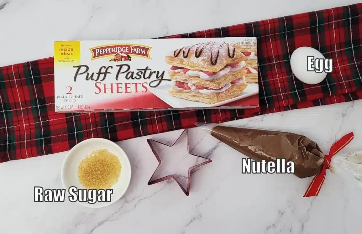 ingredients needed to make Christmas tree shaped dessert including puff pastry, Nutella, raw sugar and an egg