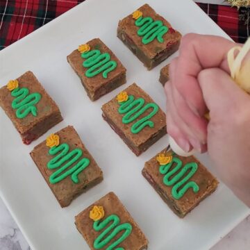 piping Christmas trees on top of holiday brown butter blondies