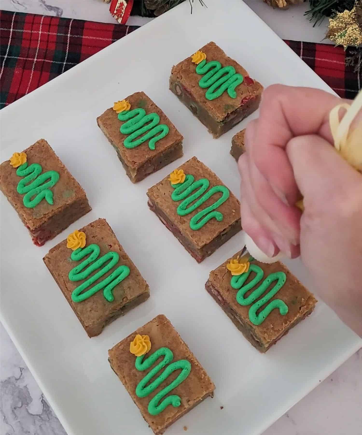 piping Christmas trees on top of holiday brown butter blondies