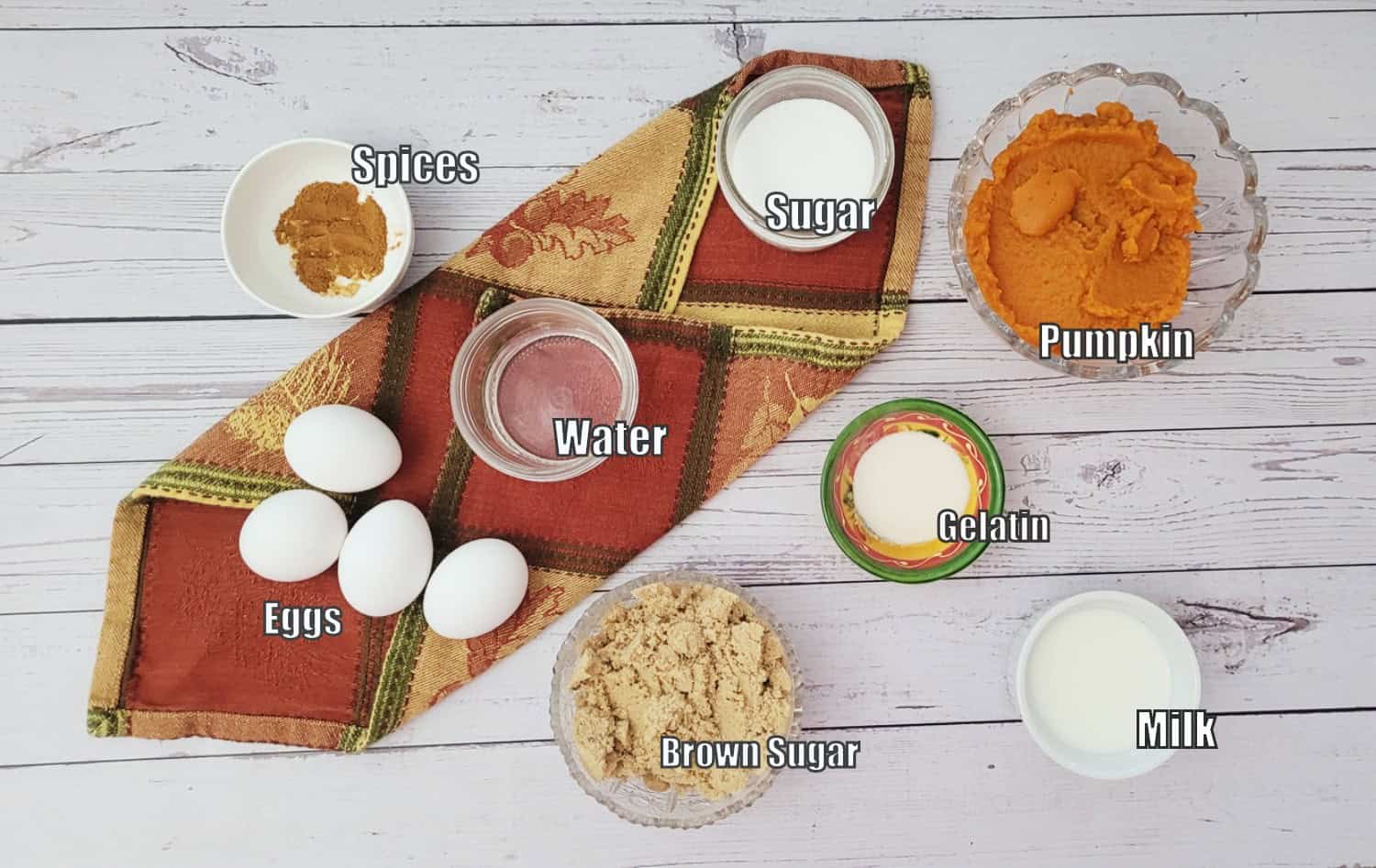 ingredients to make pumpkin mousse including spices, brown sugar, milk, sugar, gelatin, water, eggs and pumpkin puree