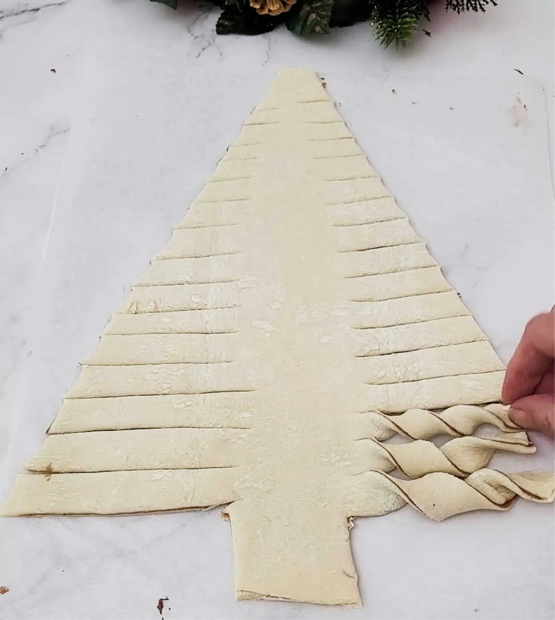 starting to twist pieces of pull apart pastry Christmas tree