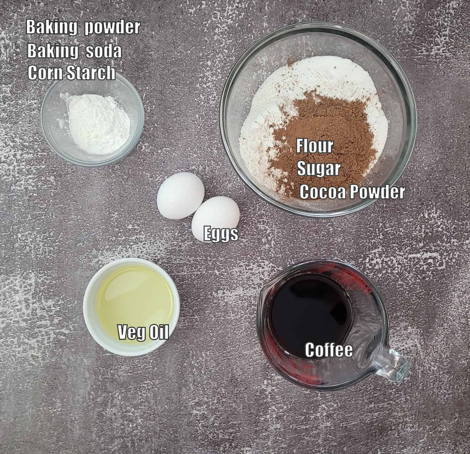 ingredients needed to make chocolate cake batter including flour, sugar, cocoa powder, baking soda, baking powder, eggs, vegetable oil and coffee