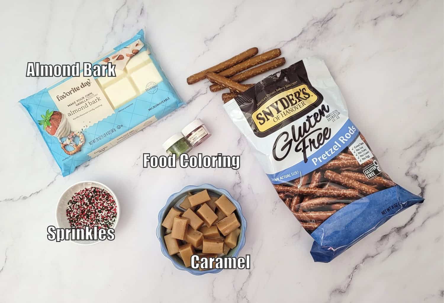 ingredients needed to make holiday pretzel rods including pretzels, caramel pieces, sprinkles, food coloring and almond bark