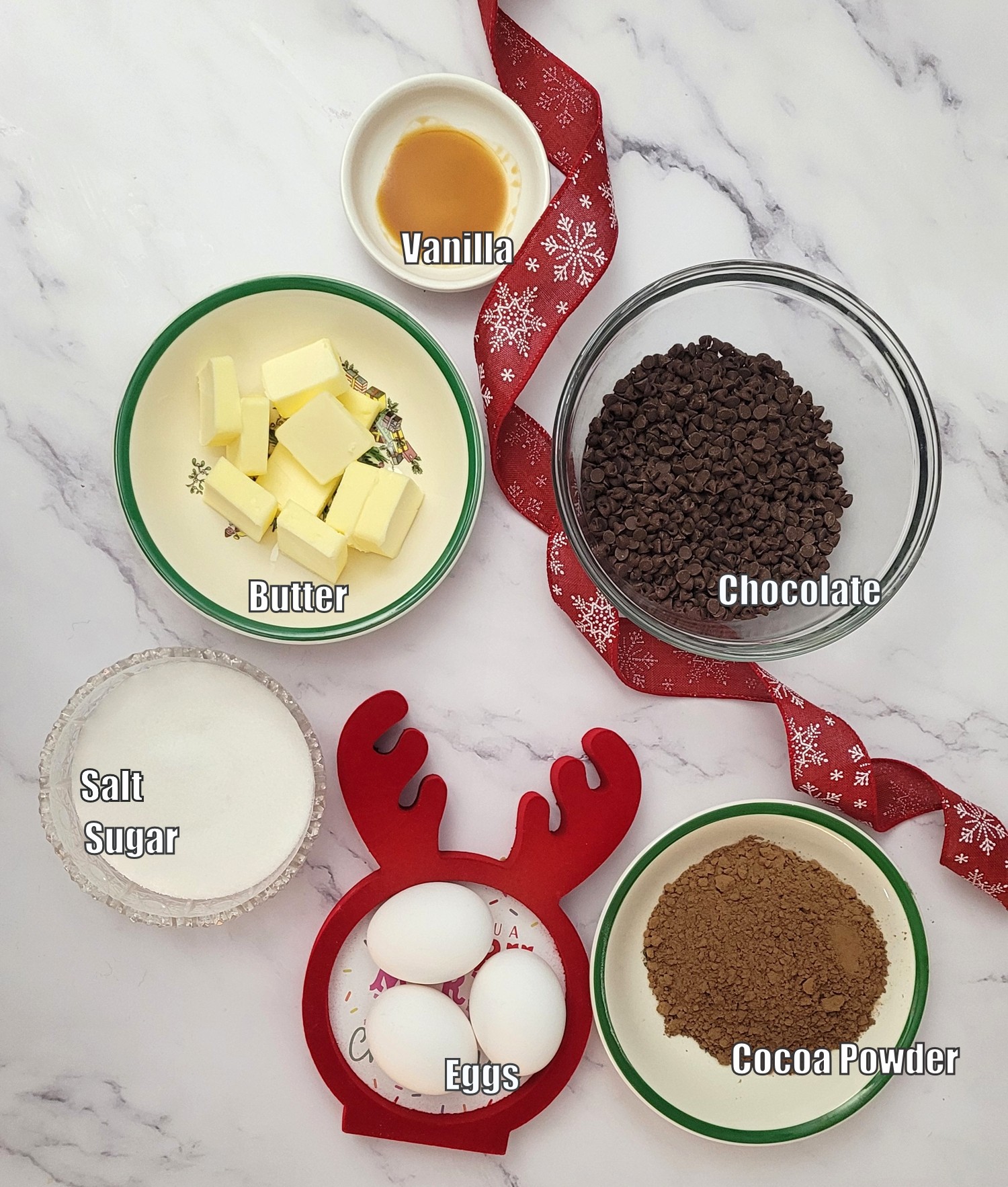 ingredients needed to make a flourless cake including eggs, salt, sugar, cocoa powder, butter, chocolate and vanilla