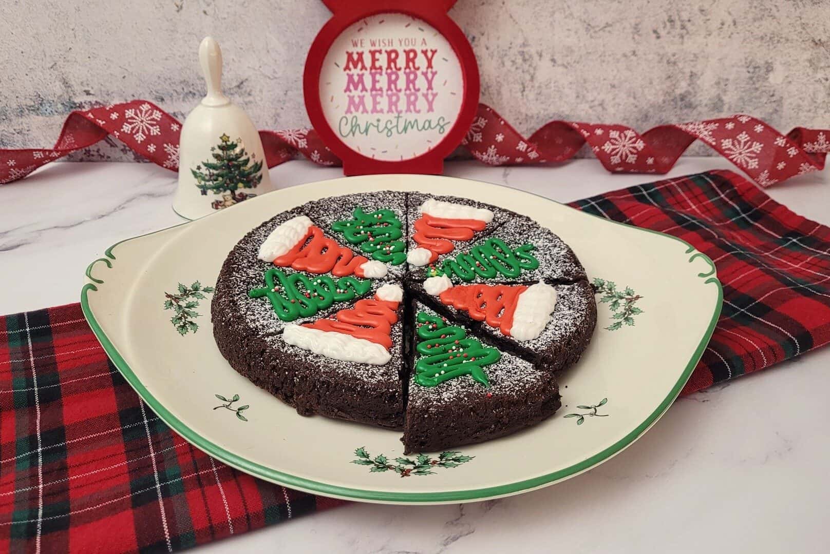 chocolate flourless Christmas cake decorated with holiday designs