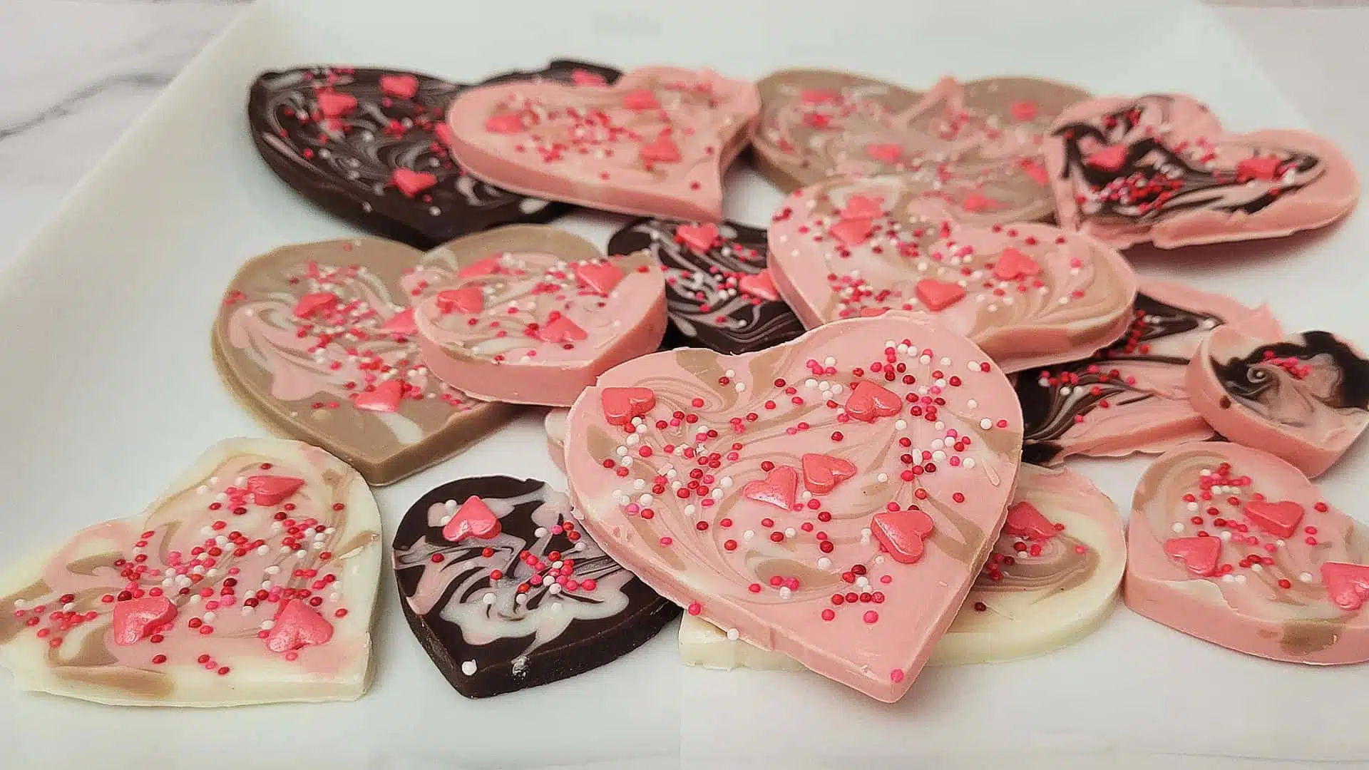 heart shaped Valentine's Day chocolate bark with pink, cream, chocolate and white swirls and sprinkles