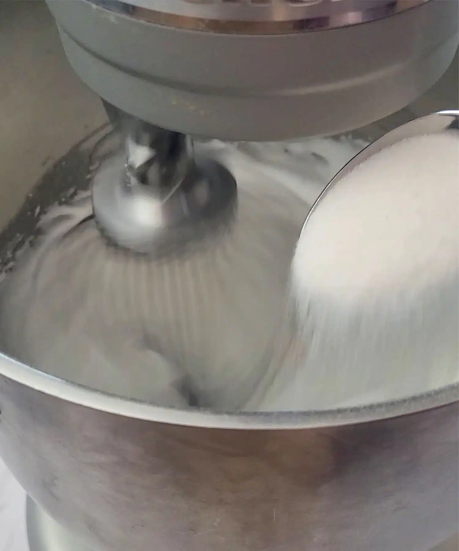 adding sugar to mixing bowl while whipping egg whites