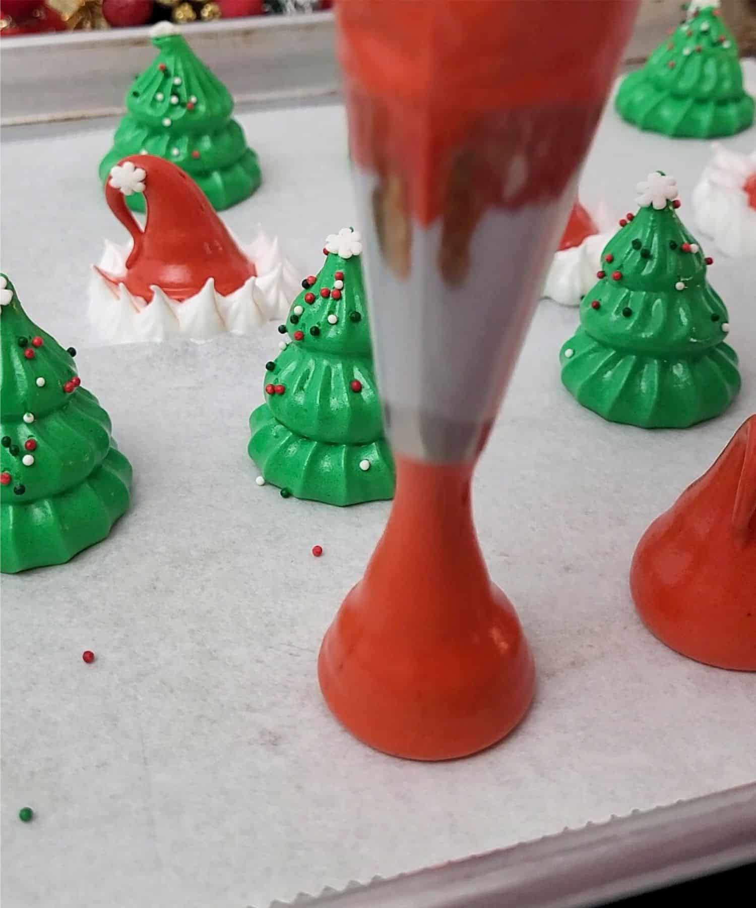 piping onto baking pan Santa hats using red meringue