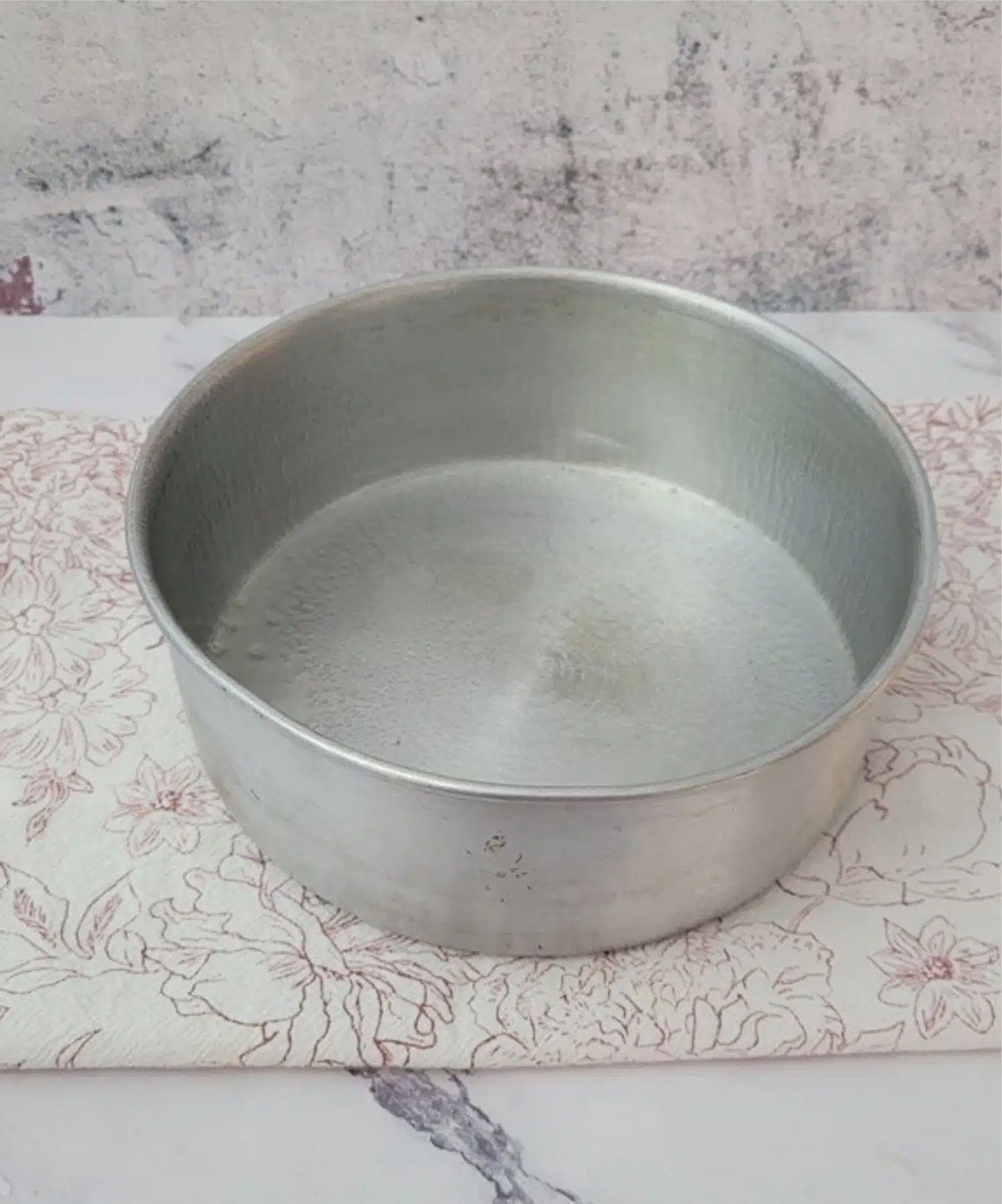 nine inch round cake pan prepared with baking spray