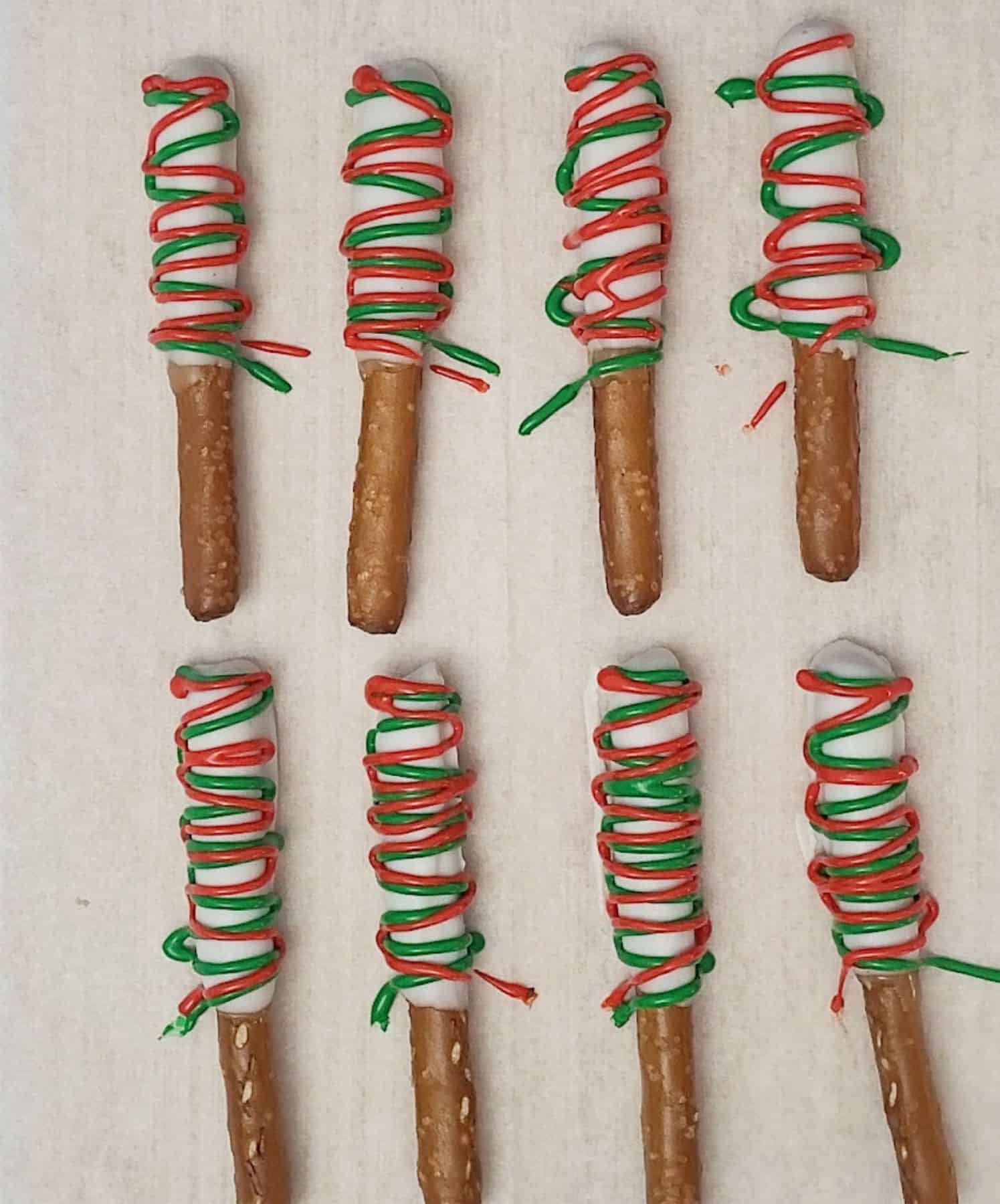 pretzel rods dipped in caramel and white chocolate and drizzled with Christmas colors