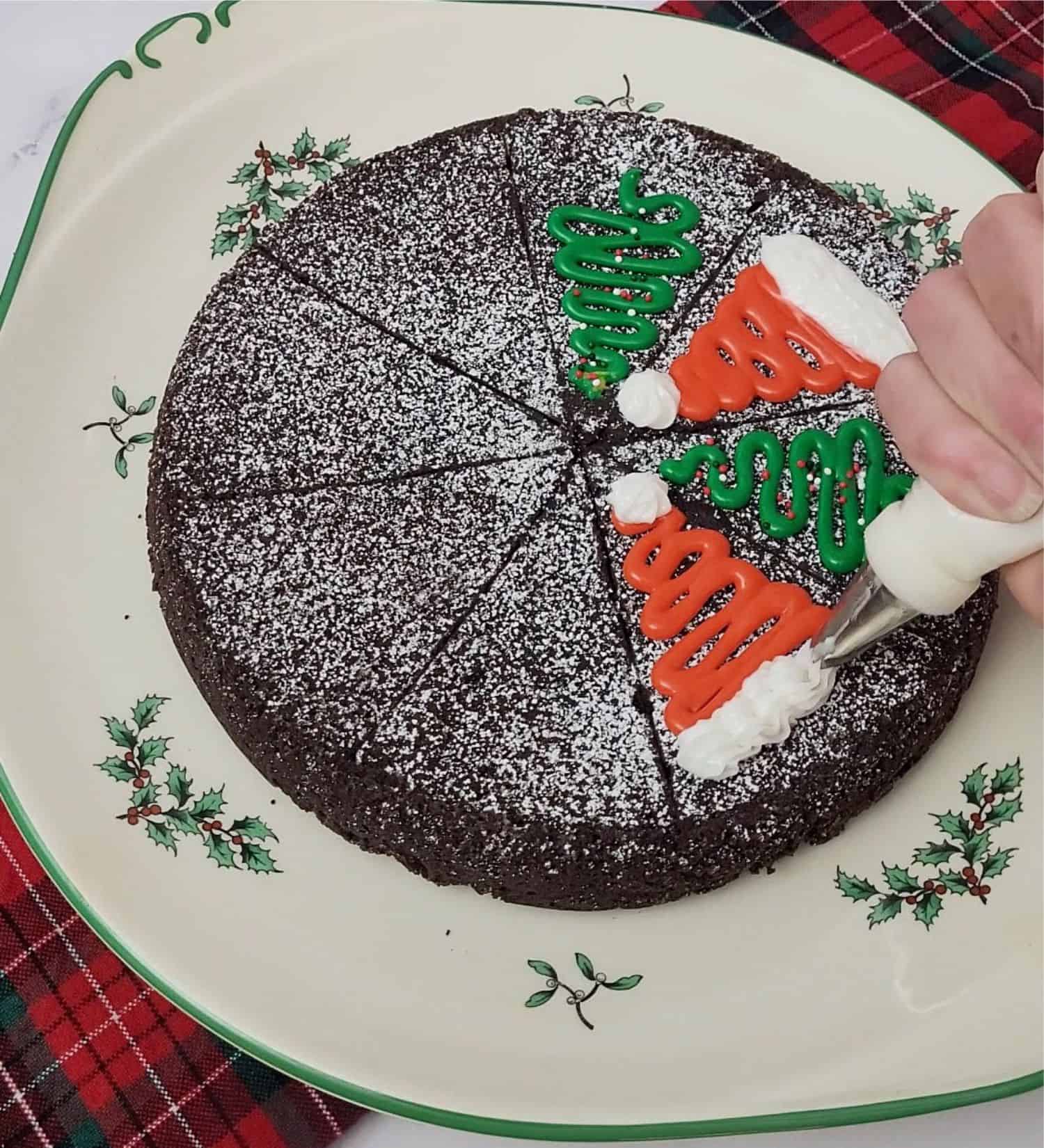 piping a Santa hat on top of a slice of cake