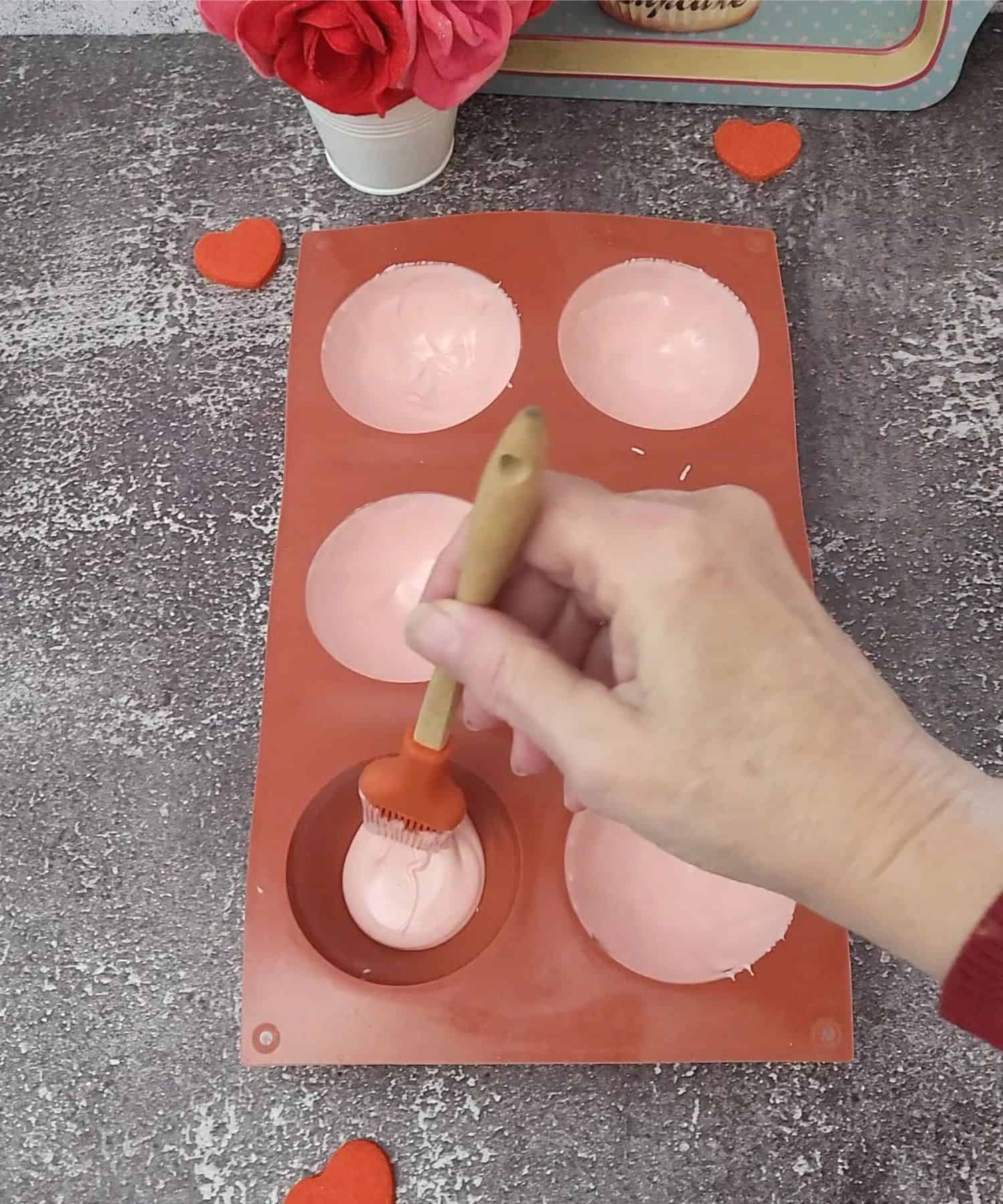 brush inside of silicone spheres with melted pink candy melts