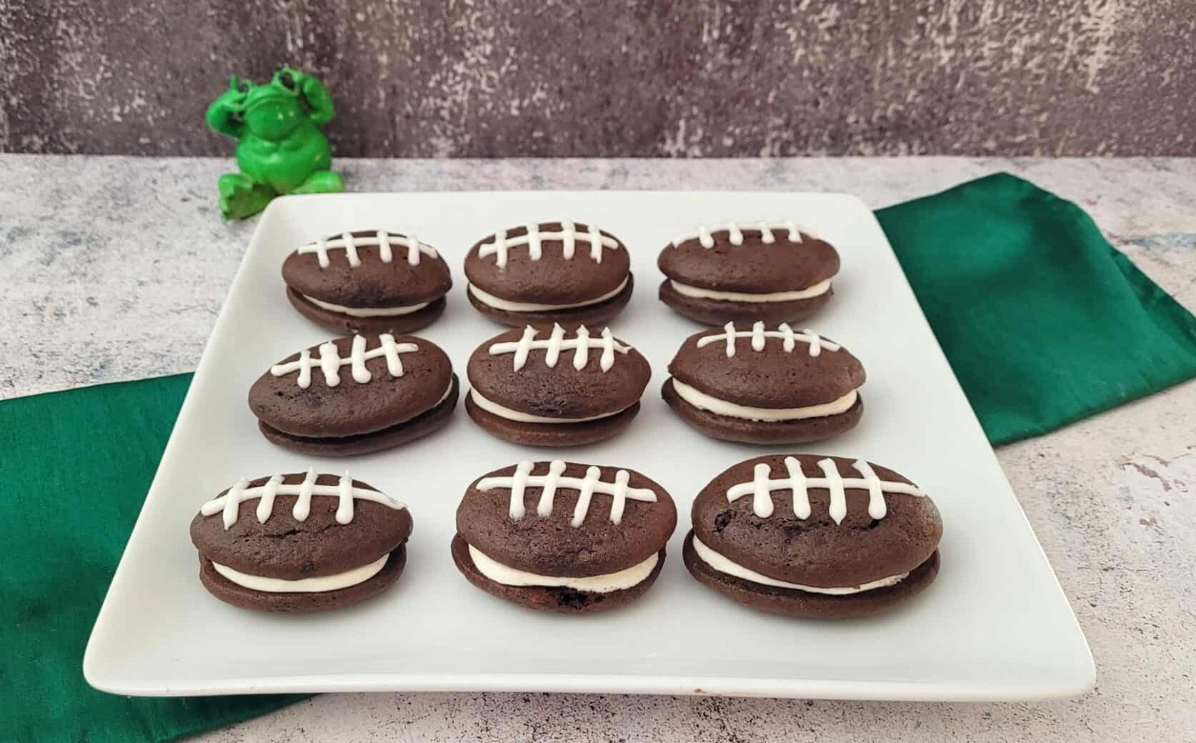 chocolate whoopie pies decorated like footballs on a serving platter