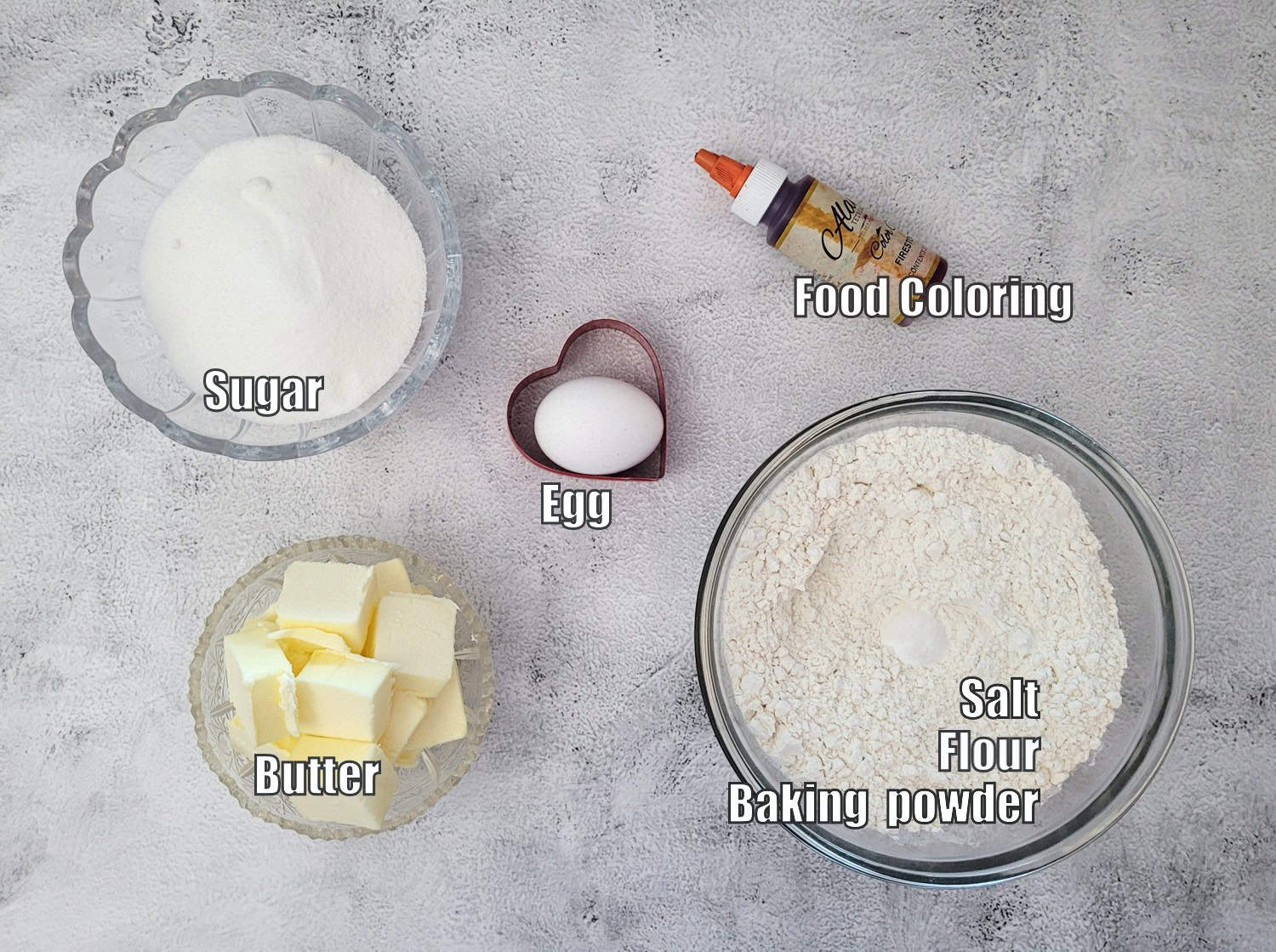 ingredients needed to make sugar cookies for Valentines day including flour, salt, baking powder, butter, granulated sugar, an egg and red food coloring