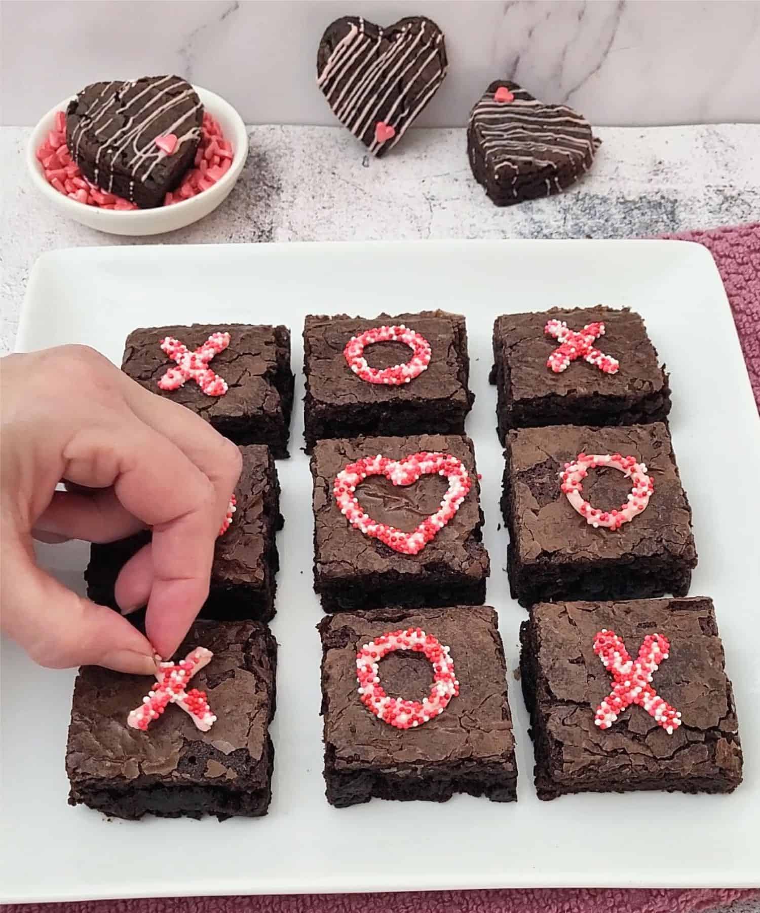 placing decorations on top of brownie squares to decorate for Valentine's day