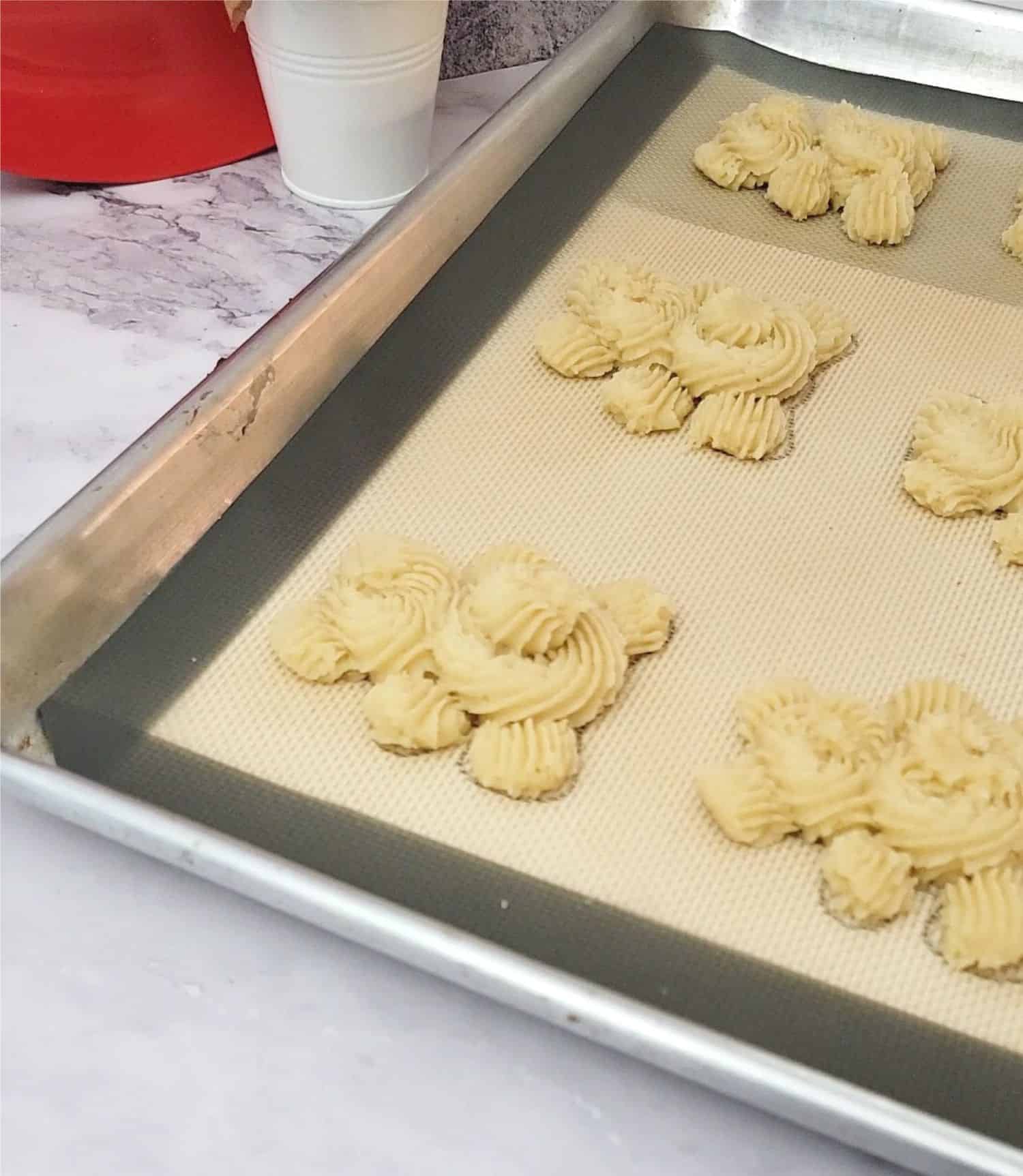 body and heads of bear butter cookies piped onto a baking pan