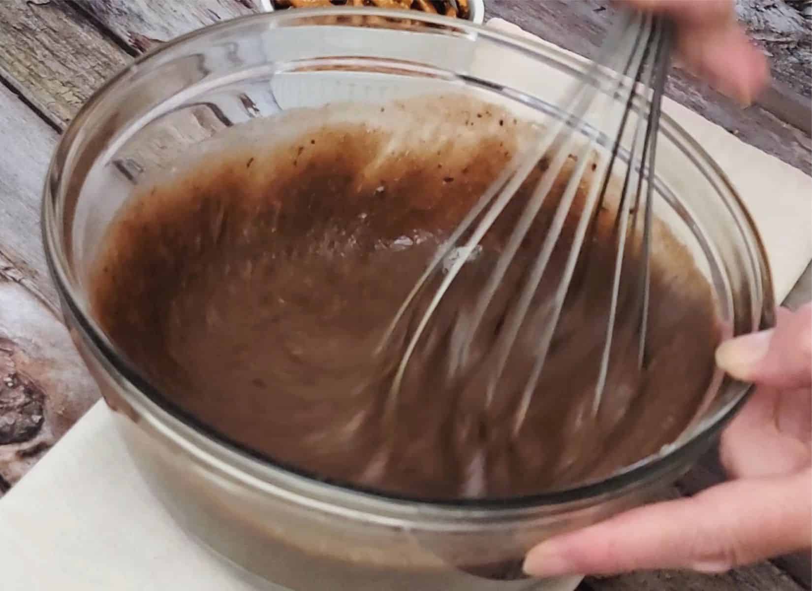 whisking wet ingredients into dry ingredients to make chocolate tart filling