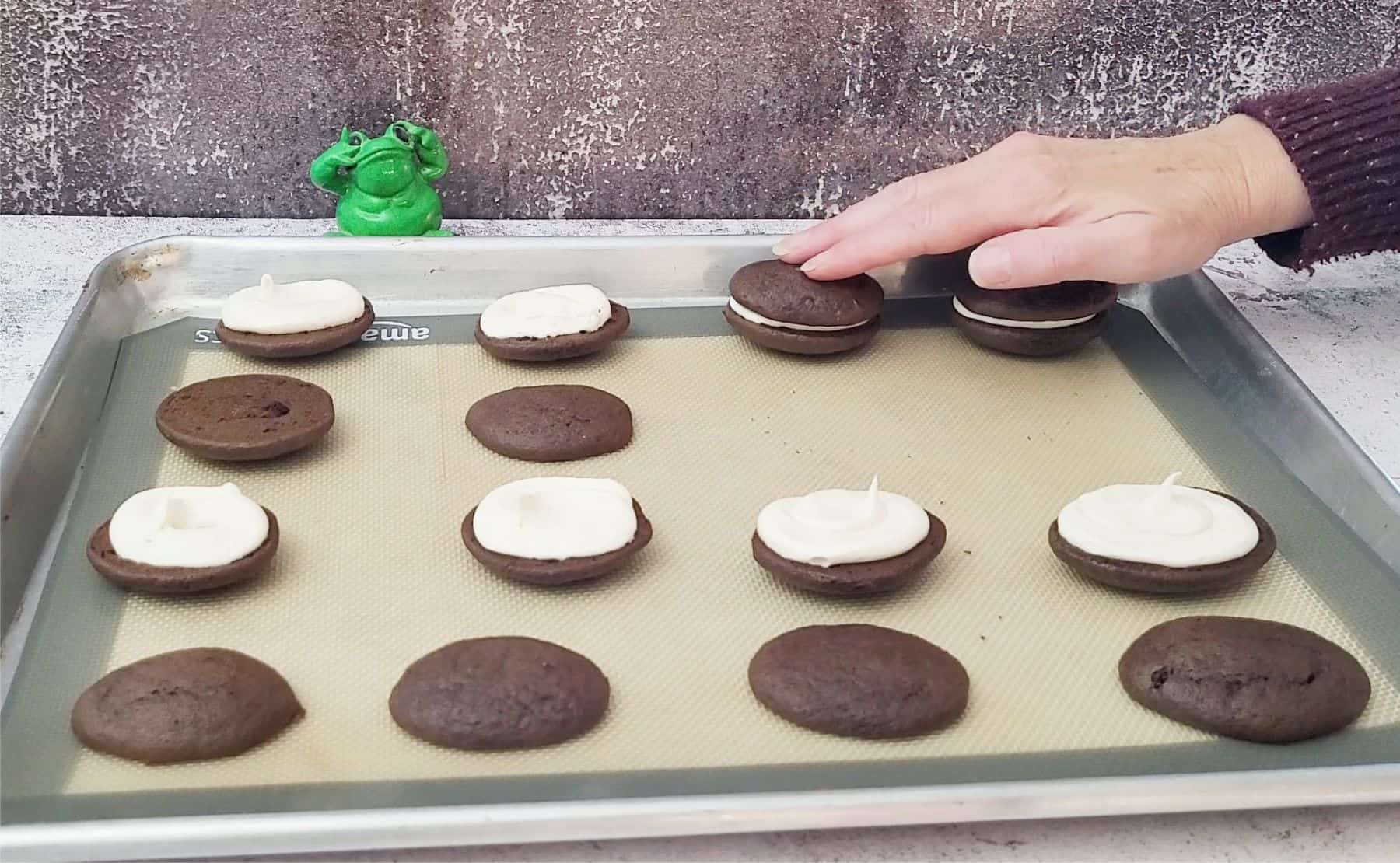 placing tops over filling on football whoopie pies made with cake mix