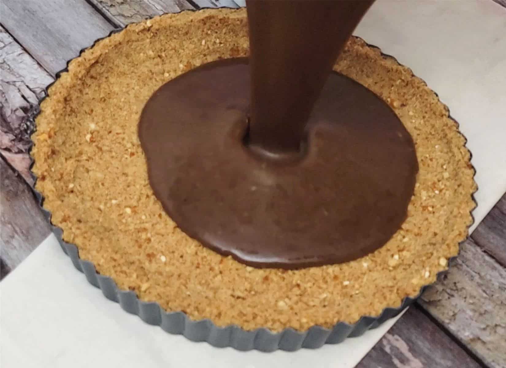 pouring filling into pan before baking chocolate pretzel tart