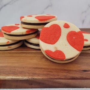 Valentines cookies with heart inlays on a wooden serving board