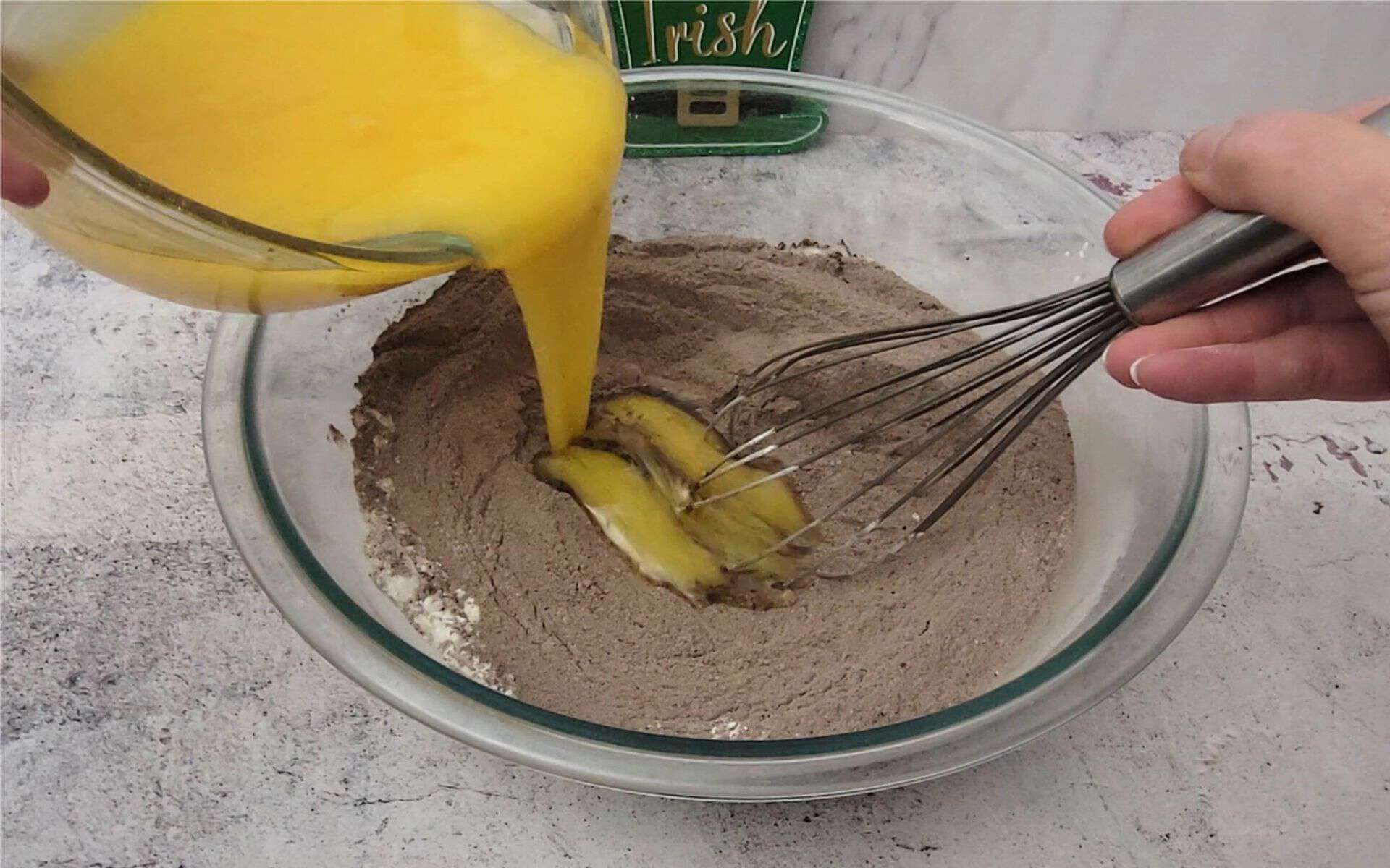 adding eggs and oil to chocolate cake dry ingredients