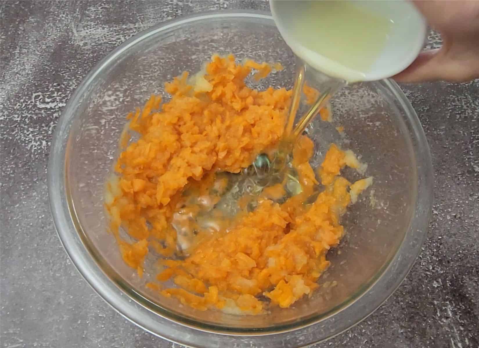 adding oil to mixing bowl with carrots and applesauce to make eggless carrot cake recipe