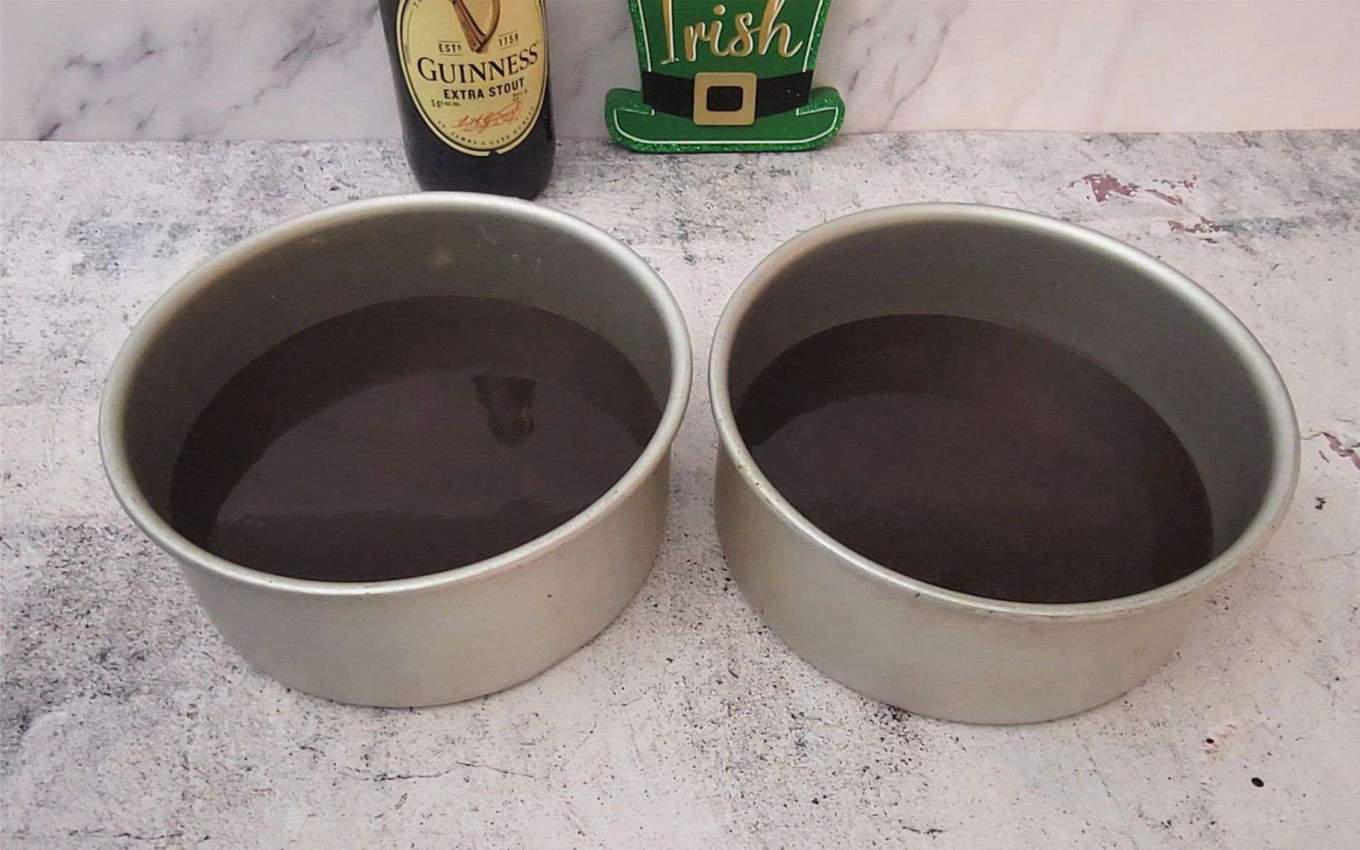 Guinness stout chocolate cake batter divided evenly between 2 round cake pans