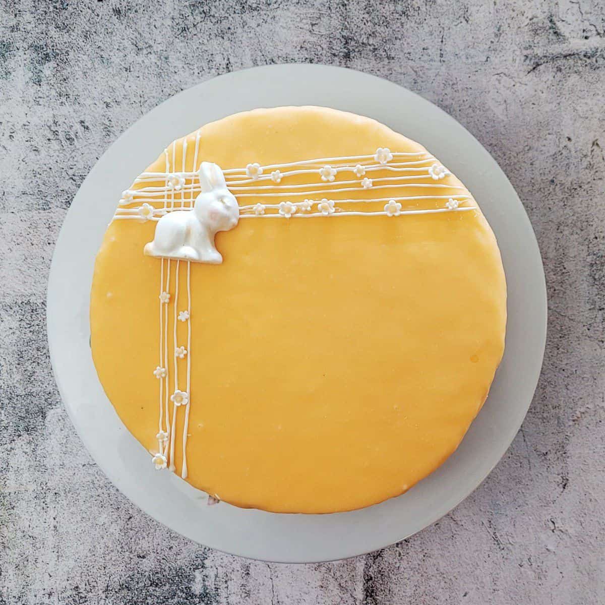 overhead view of an eggless carrot cake decorated with a white chocolate bunny