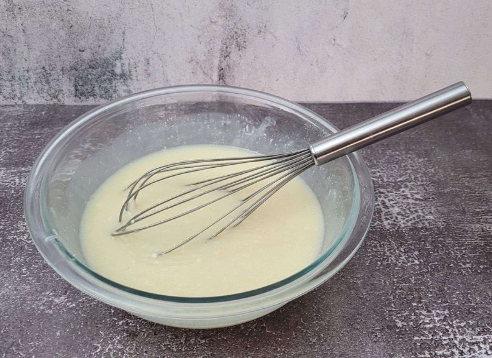 melted white chocolate added to bowl with other ingredients to make mirror glaze for cake