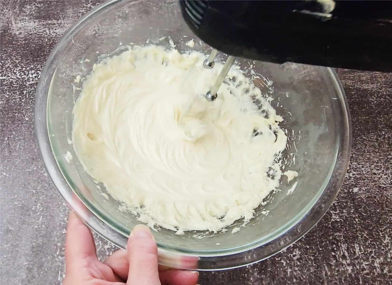 using an electric mixer to combine cream cheese, cinnamon and granulated sugar in a mixing bowl to make cream cheese mousse