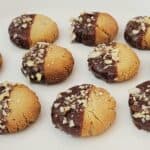 cookies made with almond flour, dipped in chocolate and sprinkled with crushed almonds