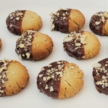 cookies made with almond flour, dipped in chocolate and sprinkled with crushed almonds