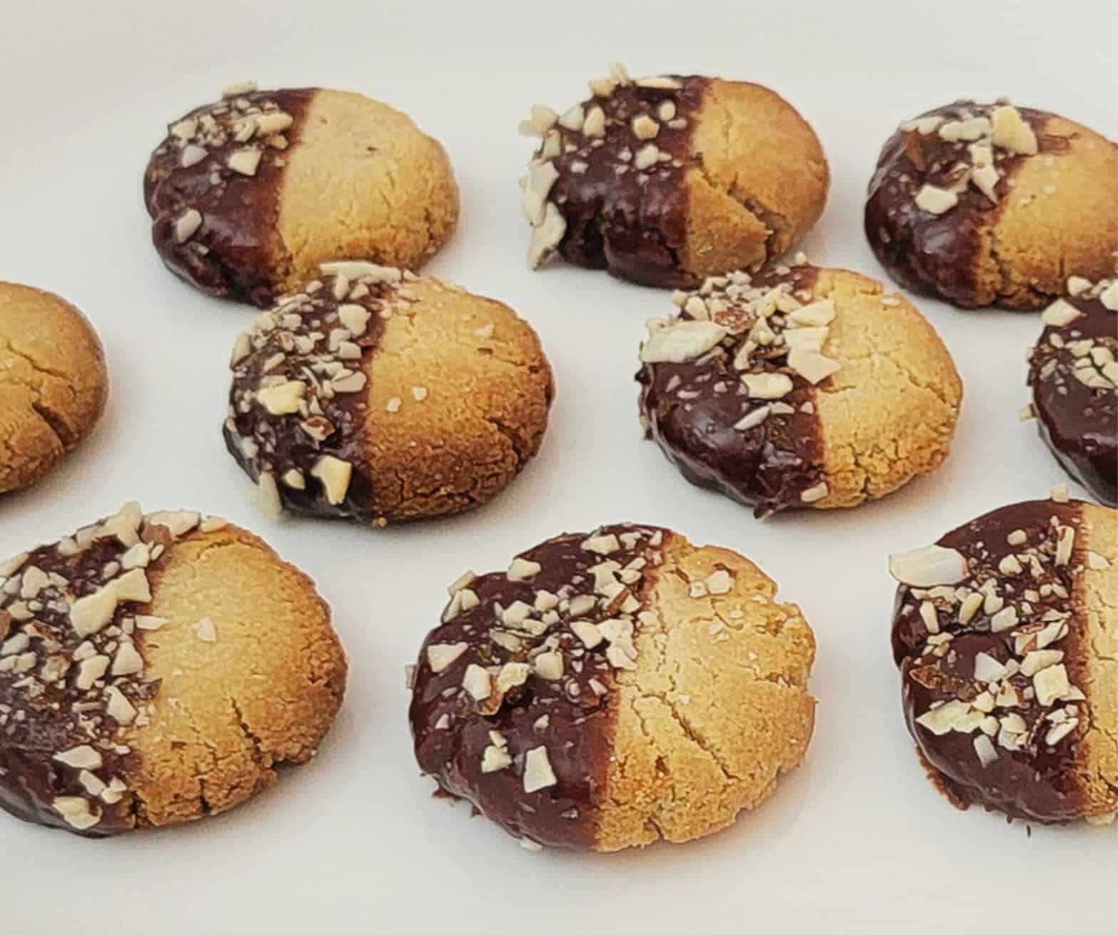 cookies made with almond flour, dipped in chocolate and sprinkled with crushed almonds