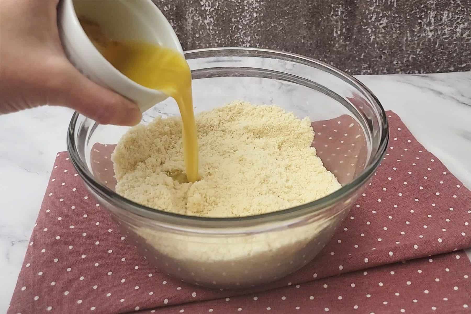 pouring melted butter, honey and vanilla extract into dry ingredients