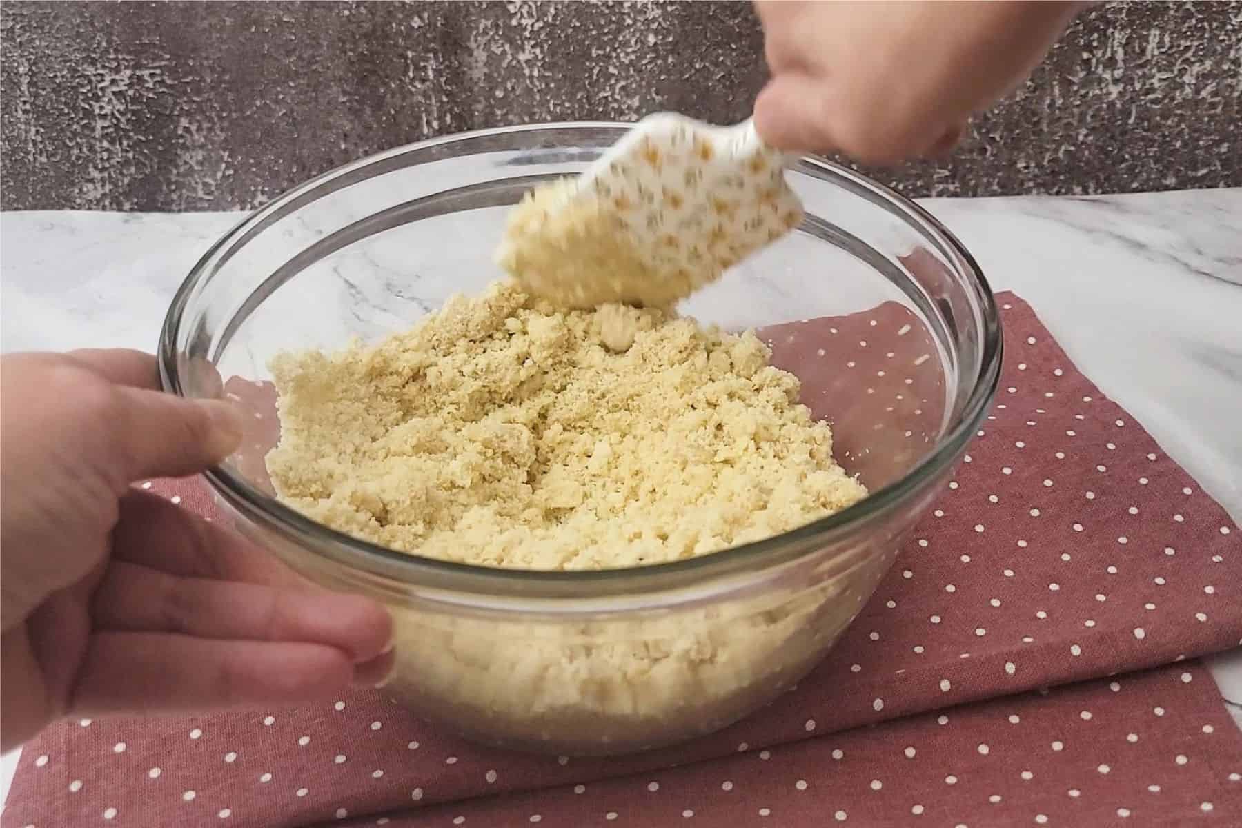 stirring wet ingredients into dry ingredients to make cookie dough