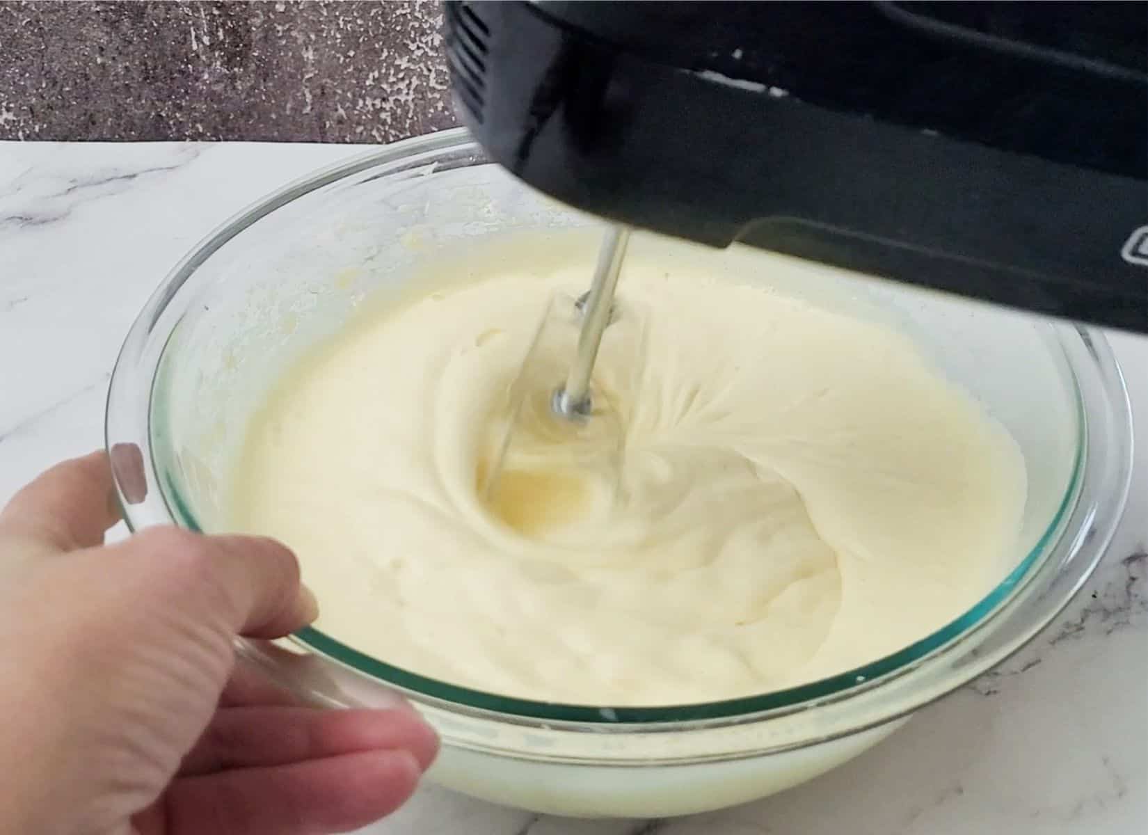 whipping together eggs and sugar until foaming to make base for almond flour cake