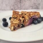 square picture of a slice of almond blueberry galette on a plate