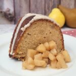 slice of pear cake on a serving dish with a serving of pear compote on the side