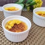three ramekins on a mat with caramelized mango crème brulee